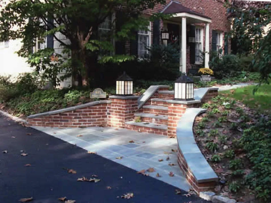 Brick entry steps with lantern piers, bluestone treads and a curved retaining wall