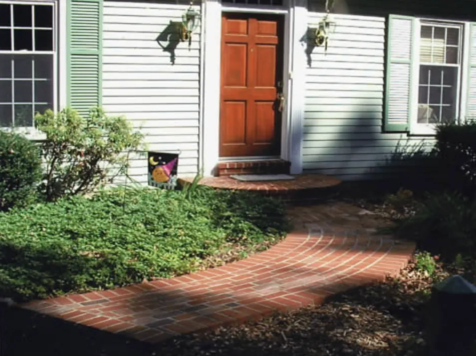Curving brick front walk leading to a half-round brick stoop
