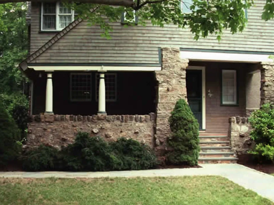 Stone porch base, pier and steps on a shingle-style home